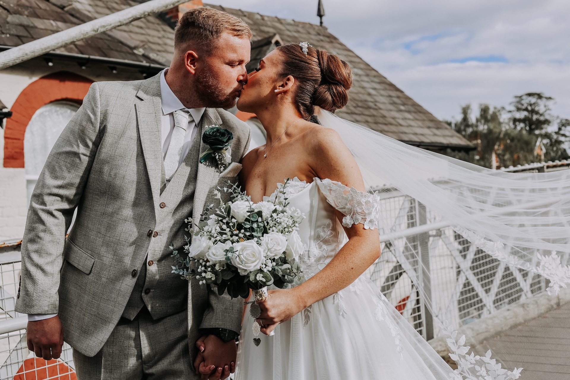 Couple kissing with the veil flowing